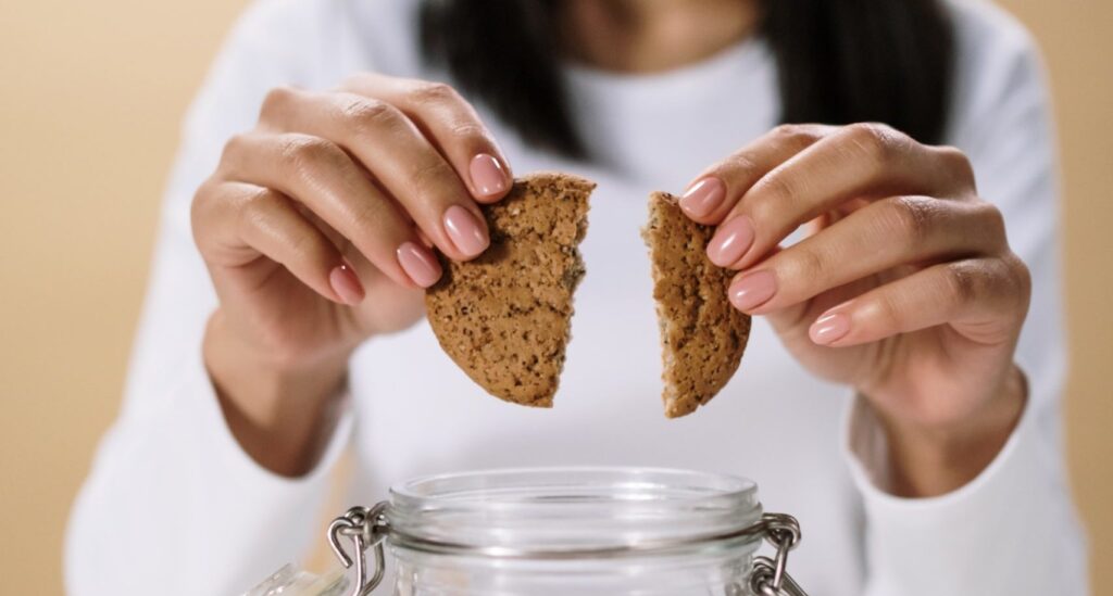 woman breaking a cookie