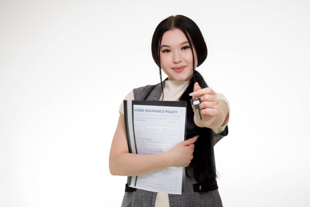 a woman holding a key and home insurance policy